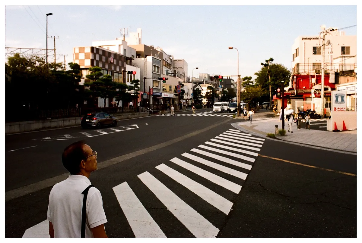 man waiting to cross the street in Kamakura, Japan